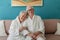 Happy senior couple sitting together in bathrobe on sofa, having nice time at home.