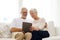 Happy senior couple with tablet pc at home