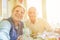Happy senior couple taking selfie portrait during united states vacation - Mature people enjoying brunch at bar restaurant -