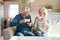 Happy senior couple talking having fun enjoying tea at home