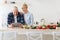 Happy senior couple use tablet, credit card, ordering food delivery in grocery in market doing shopping