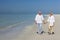 Happy Senior Couple Walking Holding Hands Tropical Beach