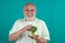 Happy Senior on Diet. Power old mature man hold broccoli. Muscular Senior man on Diet isolated in studio. Vegan senior