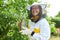 Happy senior female apiarist holding smoker