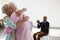 Happy senior friends applauding while looking at man and woman embracing