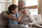 Happy senior grandfather and little grandson use smartphone