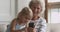 Happy senior grandmother and grandchild using smart phone at home