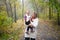 Happy senior lady and a little toddler girl, grandmother and granddaughter, enjoying a walk in autumn park