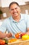 Happy senior man chopping vegetables