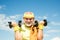 Happy Senior man exercising with lifting dumbbell outdoor. Grandfather sportsman portrait on blue sky backgrounds