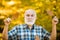 Happy senior man hiking in autumn in nature. Old man alone in autumn park.