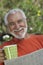Happy Senior Man Holding Coffee Cup And Newspaper