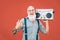 Happy senior man listening to music with boombox outdoor - Crazy hipster male having fun dancing with vintage stereo