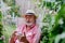 Happy senior man sitting in outdoor garden swing and scrolling smartphone.