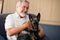 Happy senior man stroking puppy while sitting on armchair