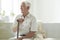 Happy senior man with walking stick relaxing in a nursing house