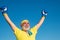 Happy Senior man wearing boxing gloves. Portrait of a determined senior boxer over blue sky background. Healthy fighter