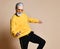 Happy senior millionaire man dancing in yellow sunglasses stylish fashionable men senior