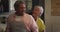 Happy senior mixed race couple putting on aprons in kitchen