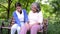 Happy senior mother with gray hair talk and laugh with daughter or caregiver in the park. Concept of happy retirement with care