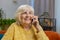 Happy senior old woman involved in pleasant conversation phone call good news enjoy talking gossip
