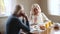 Happy senior older couple talking laughing having healthy morning breakfast