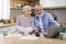 Happy Senior Spouses Making Family Budget Planning In Kitchen