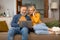 Happy Senior Spouses Using Laptop Watching Movie Sitting At Home