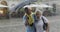 Happy senior tourists stand downtown and enjoy the rainy weather in Lviv