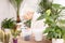 Happy senior woman cultivating potted plants at home