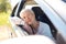 Happy senior woman driving in car with open window