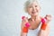 happy senior woman exercising with dumbbells and smiling