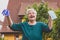 Happy senior woman holding surgical mask and medical gloves, end of corona or covid-19 pandemic