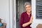 Happy senior woman leaning at door