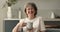 Happy senior woman posing at kitchen holding cup of tea