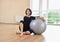 Happy senior woman resting after exercise with gray exercise ball