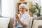Happy senior woman with smartphone at home