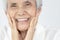 Happy senior woman is smiling confidently at beauty of new denture,false teeth in her mouth,beautiful old elderly showing new
