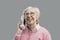 Happy senior woman talking with an old telephone