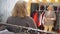 Happy senior woman trying new jacket in clothes store while shopping. Mature woman looking to mirror while fitting