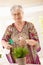 Happy senior woman watering plant