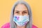 Happy senior woman wearing face mask during coronavirus outbreak - Covid-19 lifestyle concept