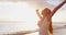 Happy serene woman relaxing joyful with arms outstretched on beach on Hawaii