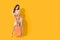 Happy Sexy Asian shopaholic woman carrying shopping bags in colorful orange and yellow background