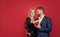 happy sexy formal couple in love embrace with present box on red background, copy space, love