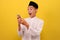 Happy Shock Young Asian Muslim man wearing muslim clothes holding mobile phone look at phone screen