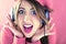 Happy shocked woman in pink listening to good sound