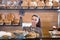 Happy shopgirl working in bakery with bread