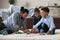 Happy sibling kids and dad playing on warm carpeted floor