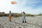 Happy siblings children running and having fun with kite on beach